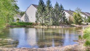 A serene lakeside view with a row of houses, a clear sky, and a calm water body. - 3 Mi to Boardwalk: Bethany Beach House w/ Patio! (Ocean View)