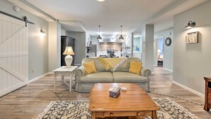 A spacious living room with a sofa, coffee table, and a kitchen in the background. - Himrod Vacation Rental 3 Mi to Seneca Lake! (Himrod)