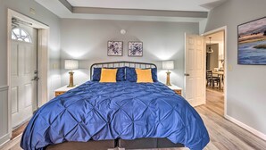A bedroom with a large bed, two bedside lamps, and a door leading to another room. - Himrod Vacation Rental 3 Mi to Seneca Lake! (Himrod)