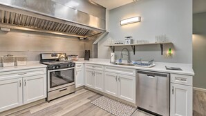 A modern kitchen with stainless steel appliances, white cabinetry, and a built-in oven. - Himrod Vacation Rental 3 Mi to Seneca Lake! (Himrod)