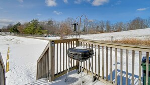 Une terrasse en bois avec un barbecue et un lampadaire.