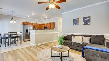 Relax in this inviting space with a central kitchen island, sofa, and dining area.