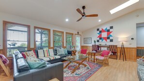 A spacious living room with a sofa, chairs, a coffee table, and a large window with blinds. - Pet-friendly Waynesville Retreat w/ Hot Tub! (Waynesville)