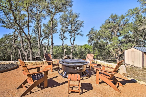 An outdoor seating area with Adirondack chairs and a circular fire pit labeled "DEAN."