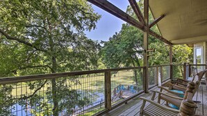 A wooden deck with a view of a lake and playground. - Family Retreat on Guadalupe River: 2 Living Areas! (Seguin)