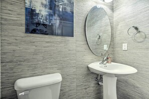 Une salle de bain moderne avec des toilettes, un lavabo et un grand miroir.