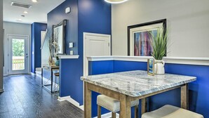 A modern kitchen with blue walls, a granite countertop, and a built-in oven. - Sleek Durham Townhome Near Dtwn w/ Balcony! (Durham)
