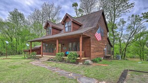 Eine Holzjagdhaus mit Veranda, Steinweg und einer US-amerikanischen Flagge.