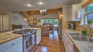 A spacious kitchen with granite countertops, a built-in stove, and a large island. - Updated Cabin on White River by Boat Landing! (Calico Rock)