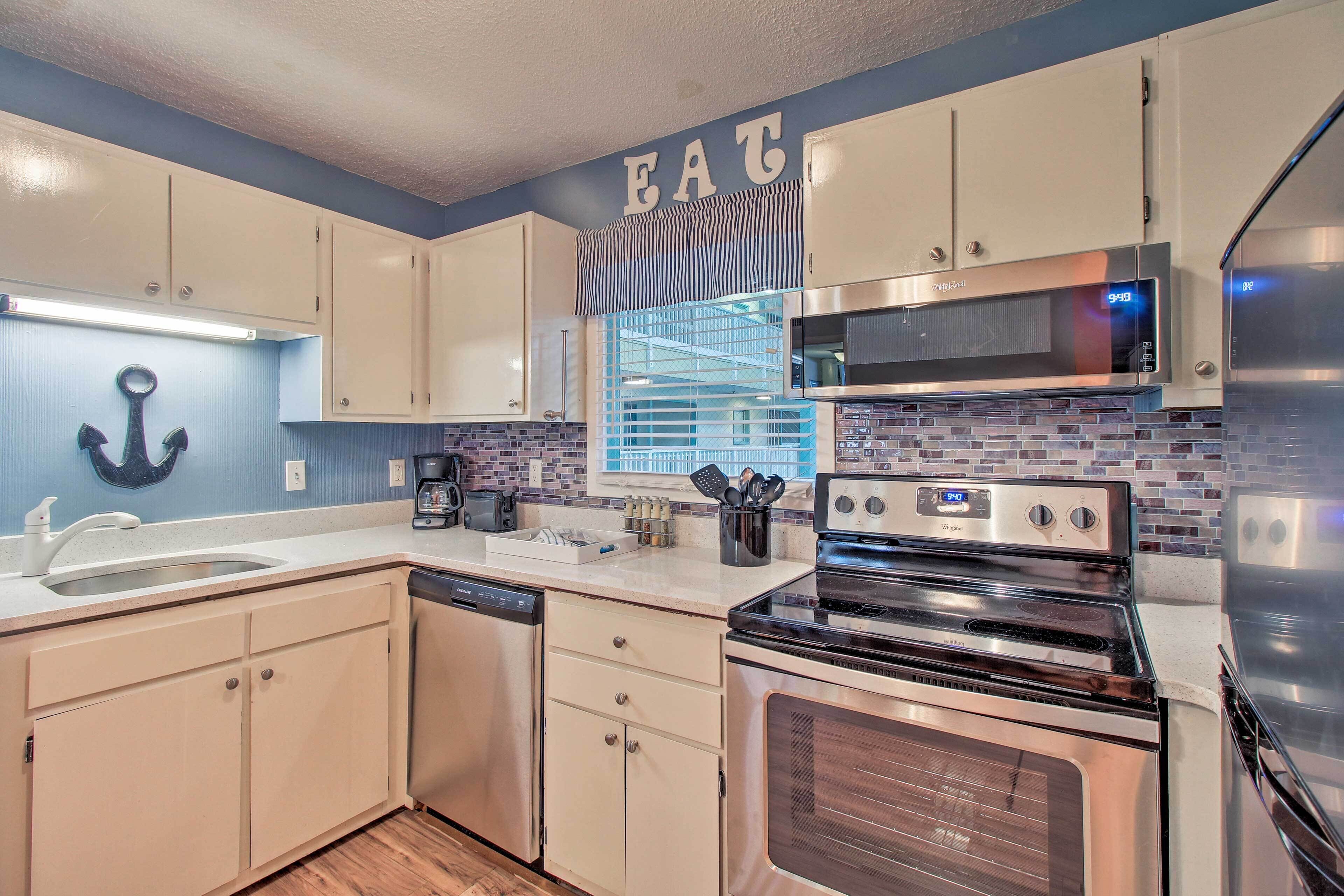 A modern kitchen with white cabinets, a stainless steel oven, and a microwave.