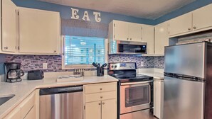 A modern kitchen with stainless steel appliances, white cabinets, and a blue accent wall. - Long-term Stays Welcome: HH Island Resort Condo (Hilton Head Island)