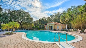 A swimming pool with a tiled deck, surrounded by palm trees and lounge chairs. - Kissimmee Getaway ~ 4 Mi to Walt Disney World (Kissimmee)