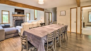 Un amplio espacio de sala con chimenea, una mesa de comedor con sillas y un sofá.