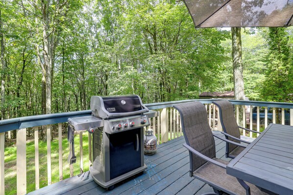 A barbecue grill on a deck with a view of a forest. - Hot Tub + Game Room: Peaceful Poconos Home! (Lake Harmony)