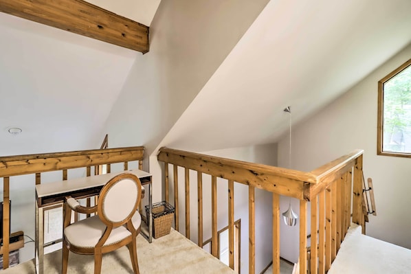 A room with a wooden desk, chair, and a small table. - Hot Tub + Game Room: Peaceful Poconos Home! (Lake Harmony)