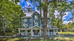 A two-story house with a porch, surrounded by trees. - Stunning South Fallsburg Home w/ Pool & Deck! (South Fallsburg)