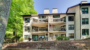 A multi-story building with balconies, a star decoration, and a landscaped area with a wooden deck. - 1 Mi to Big Boulder: Lakefront Unit w/ Pool Access (Lake Harmony)