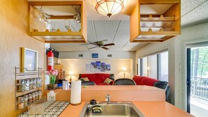 A compact kitchen with a sink, a ceiling fan, and a dining area with a red sofa. - 1 Mi to Big Boulder: Lakefront Unit w/ Pool Access (Lake Harmony)