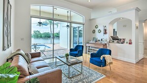 Amplia sala de estar con un gran ventanal, un sofá, una mesa de centro y un sillón azul.