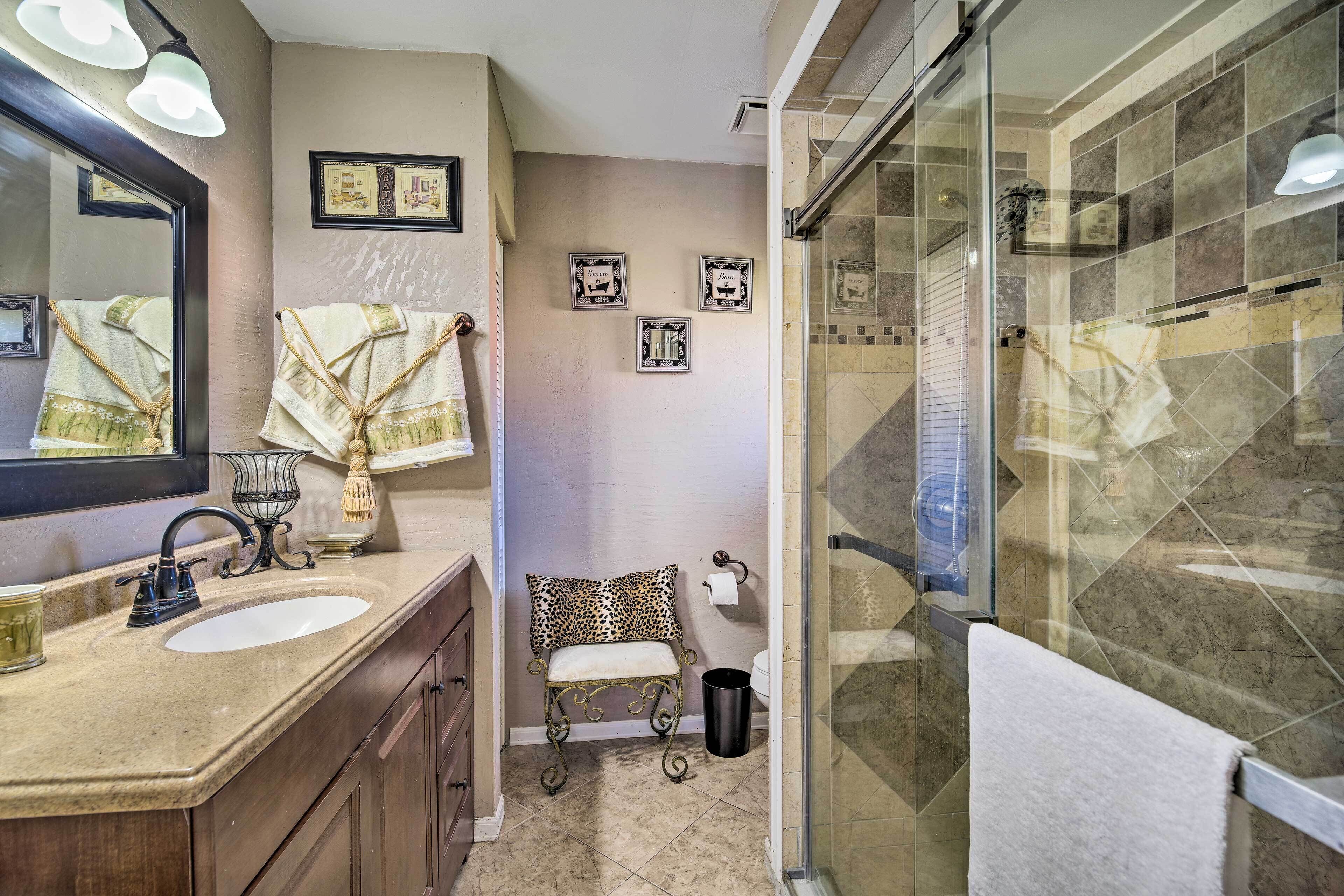 A bathroom with two sinks, a mirror, a shower, and a towel rack.