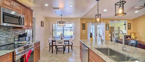 A spacious kitchen with granite countertops, stainless steel appliances, and wooden cabinets.