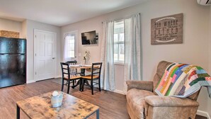 A compact living space with a dining area, a sofa, and a television.