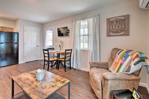 A compact living space with a dining area, a sofa, and a television. - Updated Missouri Cabin Rental on Large Farm (Canton)
