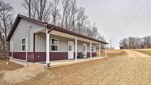 A single-story building with a covered porch and a gravel driveway.