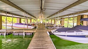 A covered boat dock with multiple moored boats, wooden walkways, and a central open space. - Pet-friendly Cabin With Designated Boat Slip! (Higden)