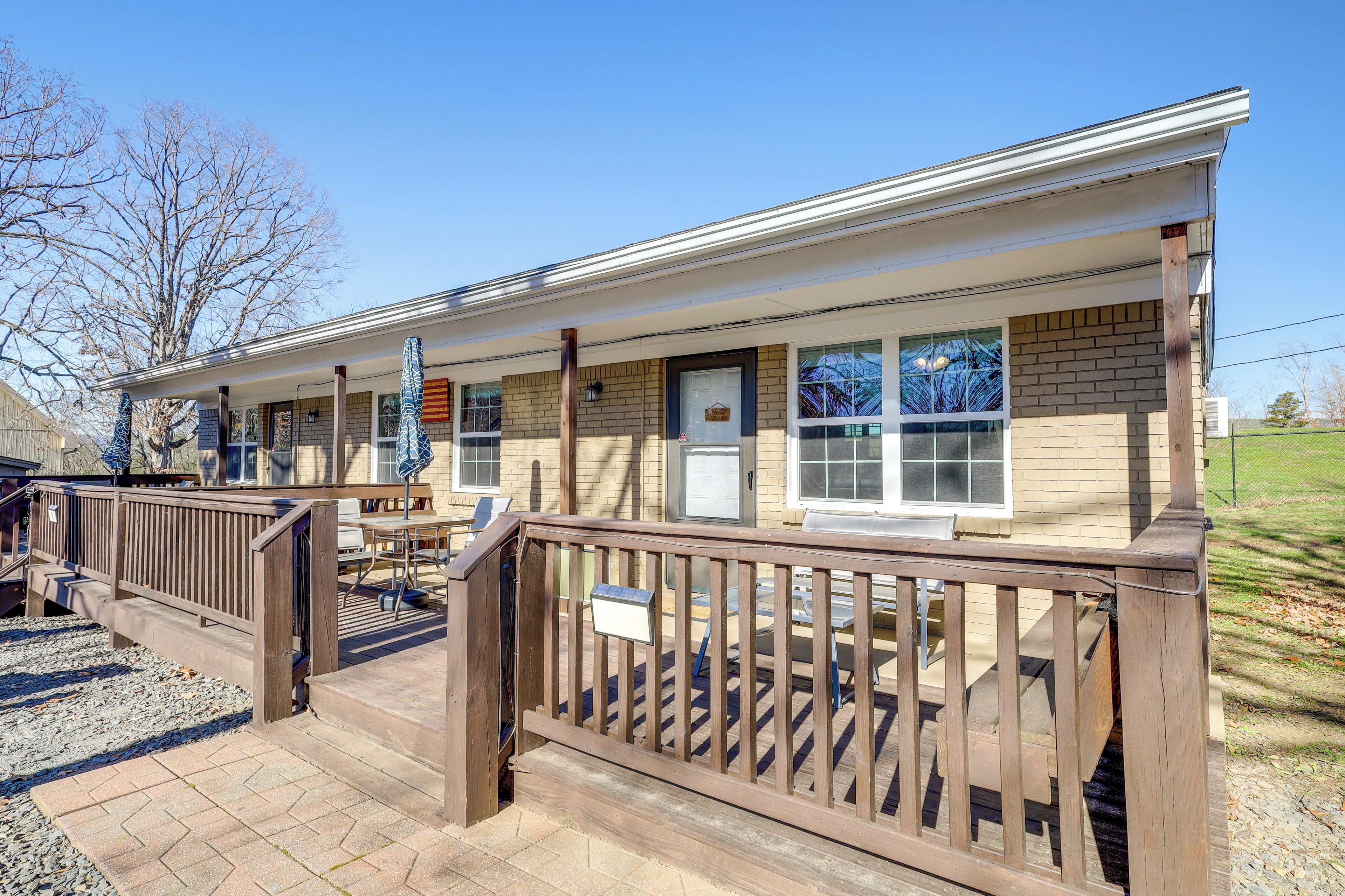 A single-story building with a covered porch, a brick exterior, and a wooden deck.