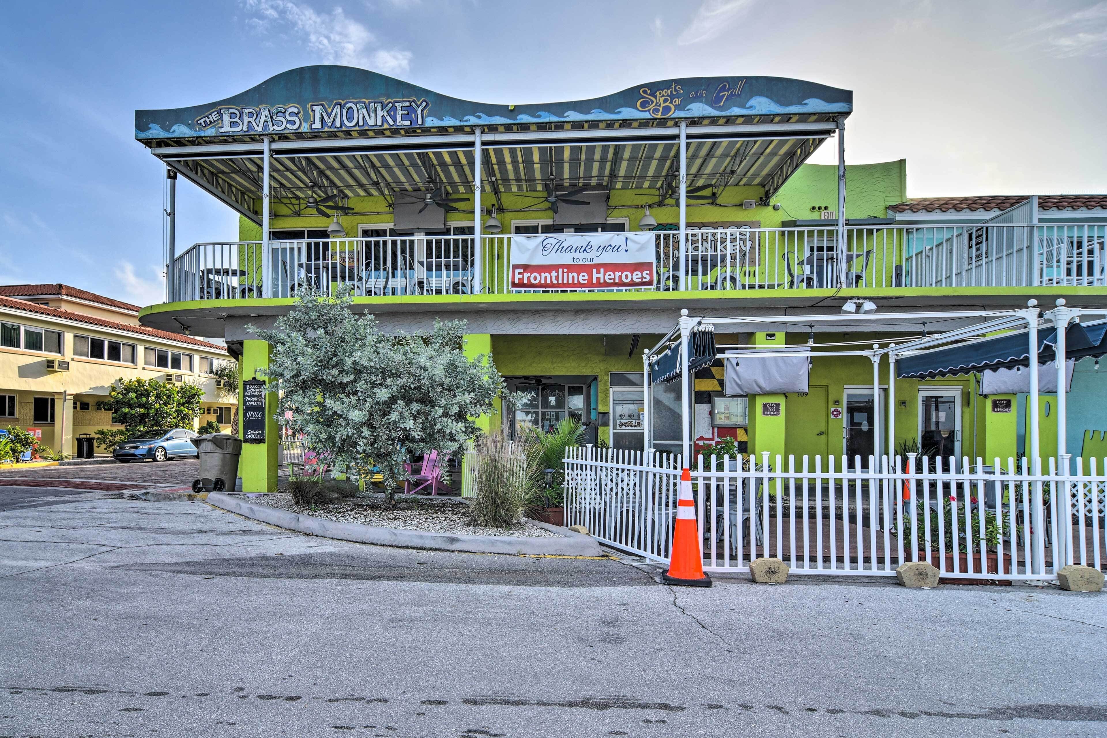A two-story building with a green facade, a sign reading "The Brass Monkey," and a banner thanking "Frontline Heroes."