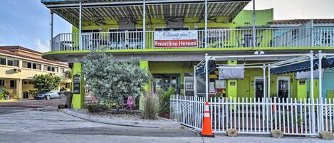 A two-story building with a green facade, a sign reading "The Brass Monkey," and a banner thanking "Frontline Heroes."