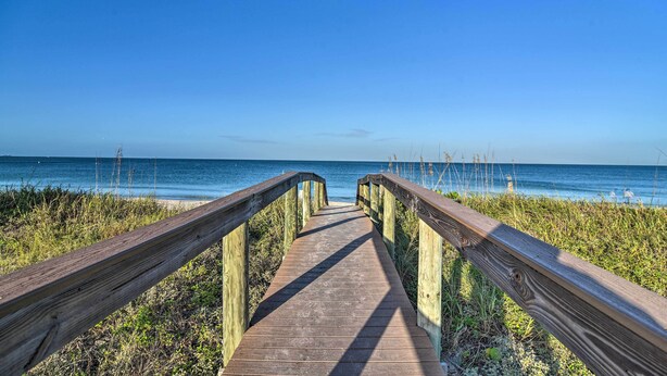 A wooden boardwalk leading to a beach with clear skies. - Tropical Pass-a-grille Gem w/ Direct Beach Access! (St. Pete Beach)