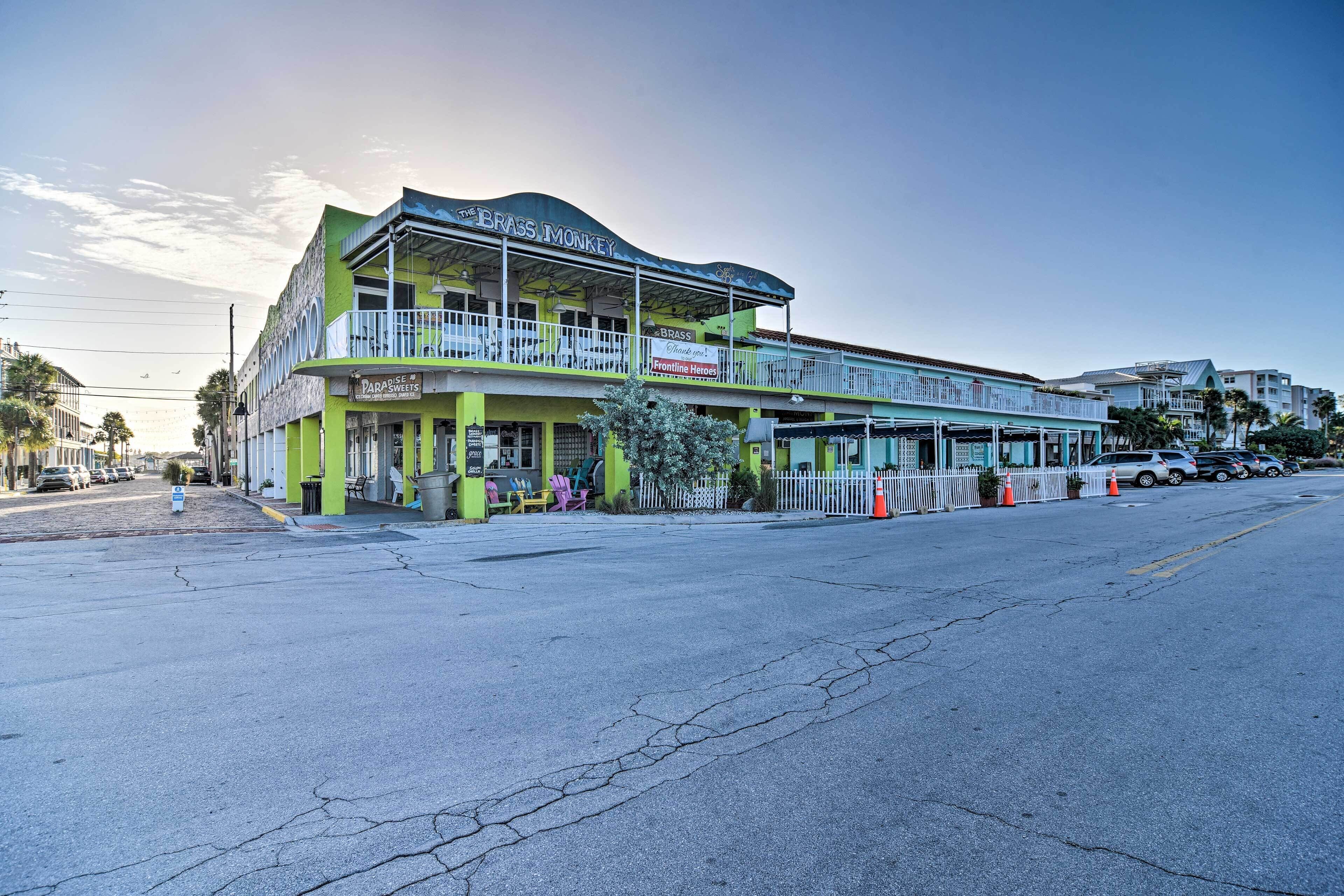 A two-story building with a green facade and a sign reading "The Brass Monkey."