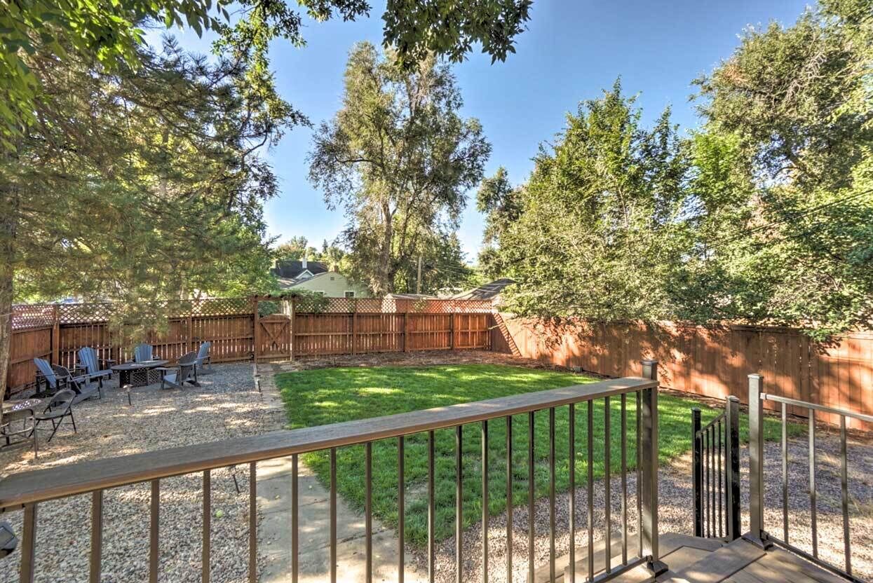 A backyard with a wooden deck, a patio table, and chairs.