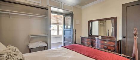 A bedroom with a bed, a dresser, a mirror, and a closet.
