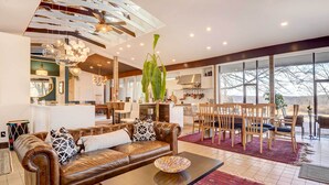 A modern living room with a leather sofa, a coffee table, and a dining area with wooden chairs and a red rug. - Stylish + Serene West Friendship Hidden Gem! (West Friendship)