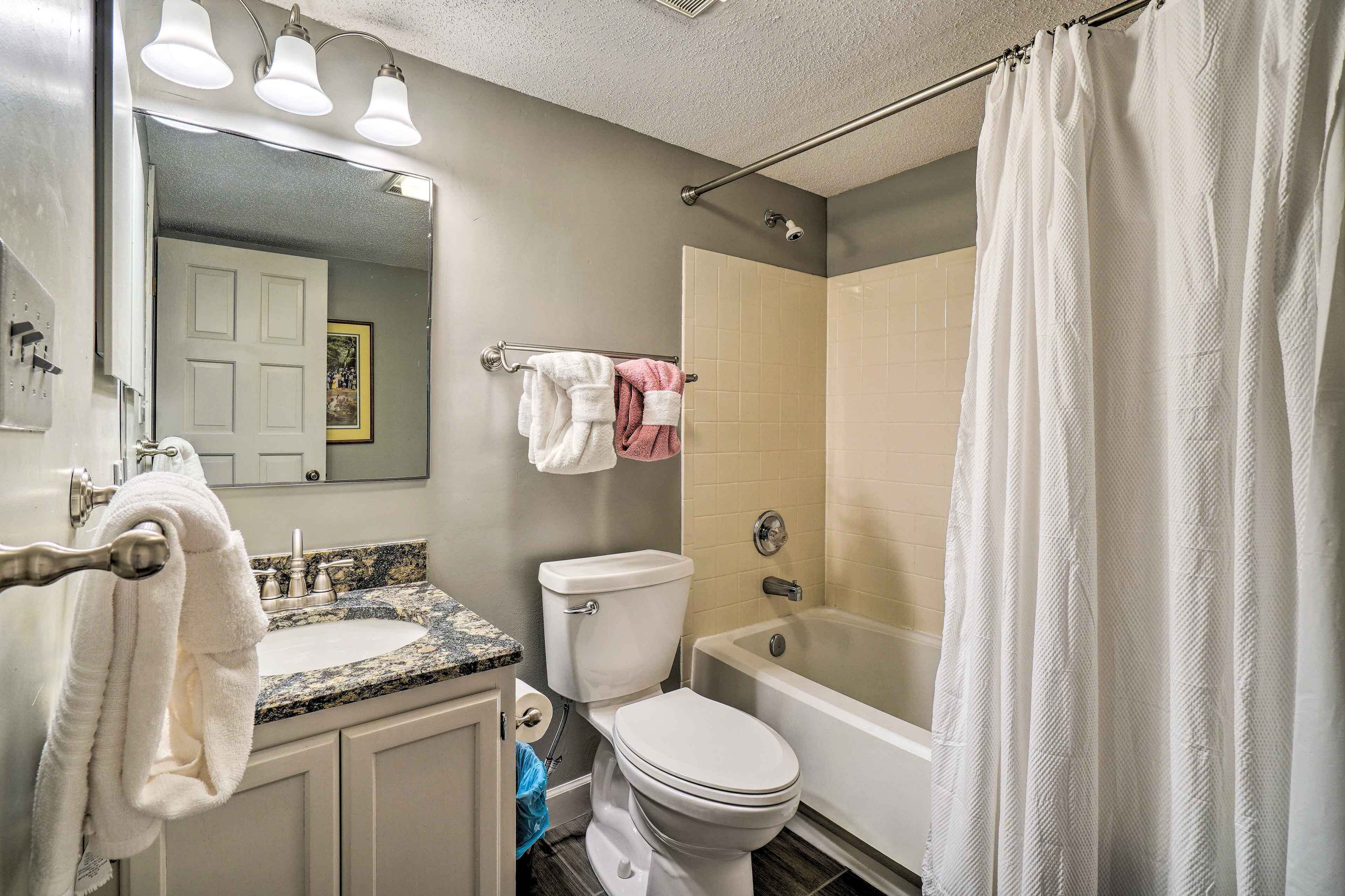 A bathroom with a sink, toilet, and bathtub.