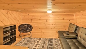 A wooden interior with a sofa, a patterned rug, and a chair. - Bryson City Cabin w/ Private Hot Tub & Game Room (Bryson City)