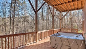 A wooden deck with a hot tub, surrounded by a wooden railing, overlooking a forested area. - Bryson City Cabin w/ Private Hot Tub & Game Room (Bryson City)
