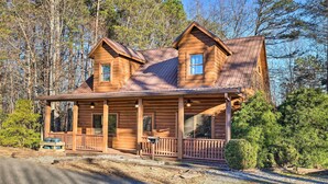 A wooden cabin with a porch, two windows, and a chimney. - Bryson City Cabin w/ Private Hot Tub & Game Room (Bryson City)