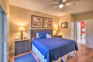 A bedroom with a large bed, two bedside tables with lamps, a ceiling fan, and framed pictures on the wall. - 6 Mi to Boardwalk: Condo w/ Pool in Myrtle Beach (Myrtle Beach)