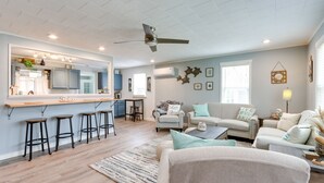 A modern living room with a kitchen area, a ceiling fan, and a bar stool setup. - Pittsburg Vacation Rental < 1 Mi to Boat Launch (Pittsburg)