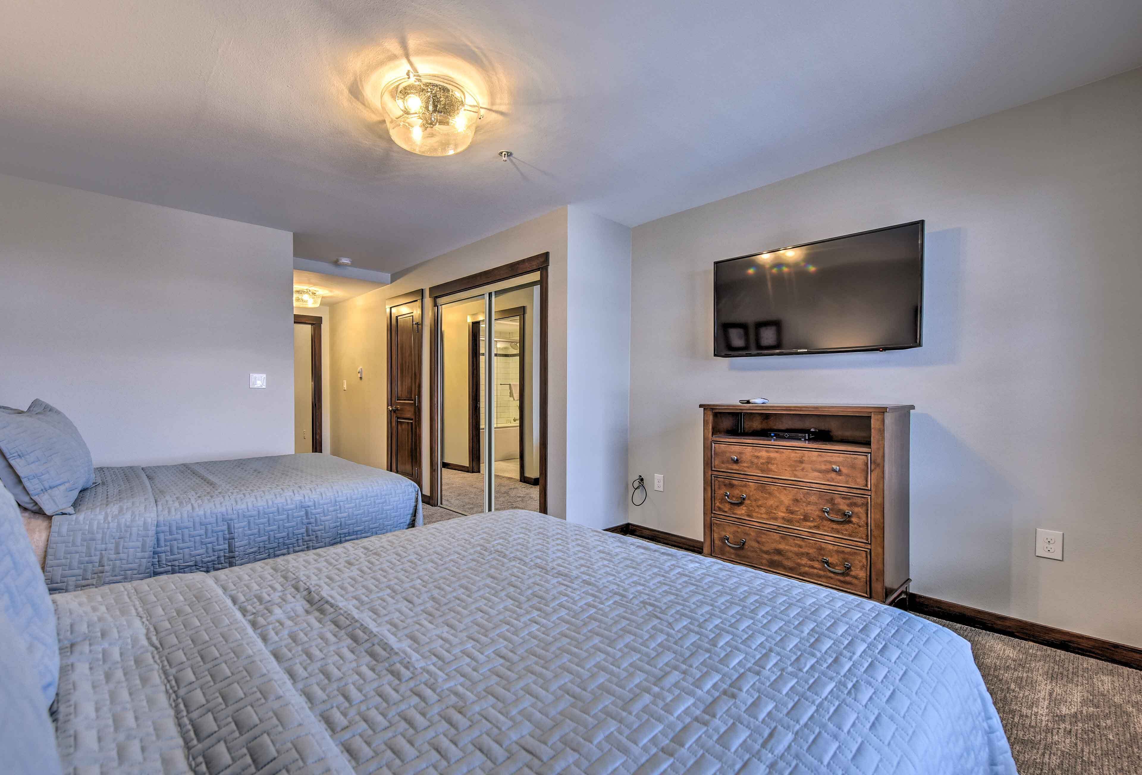 Un dormitorio con dos camas, un televisor y un aparador de madera.