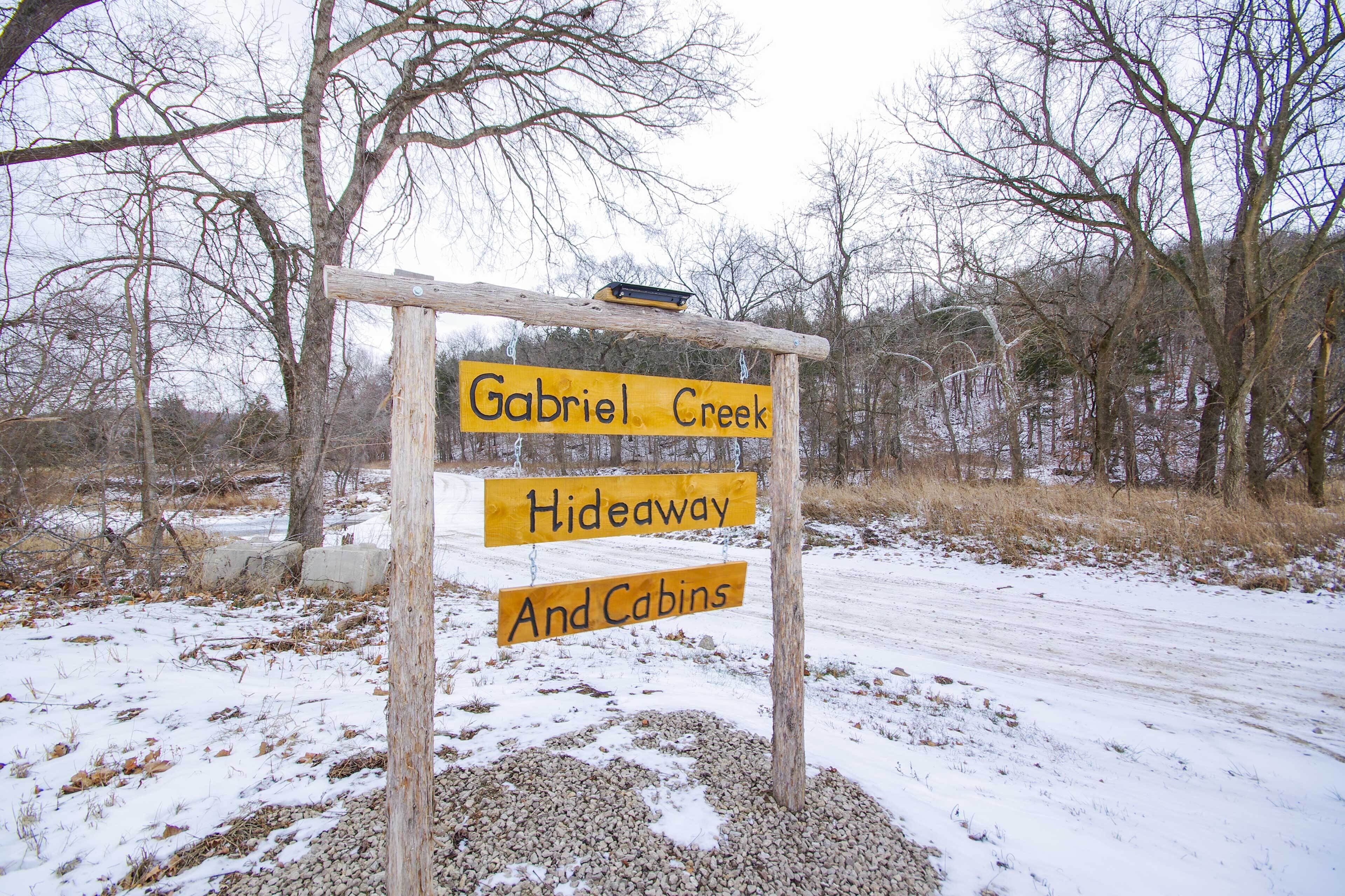A wooden sign with "Gabriel Creek Hideaway And Cabins" written on it.