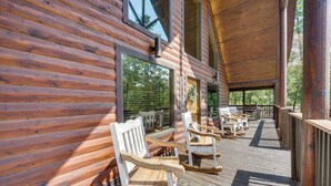 A wooden deck with rocking chairs and a welcome sign. - 'penny Lane Lodge' Broken Bow Cabin < 6 Mi to Lake (Broken Bow)