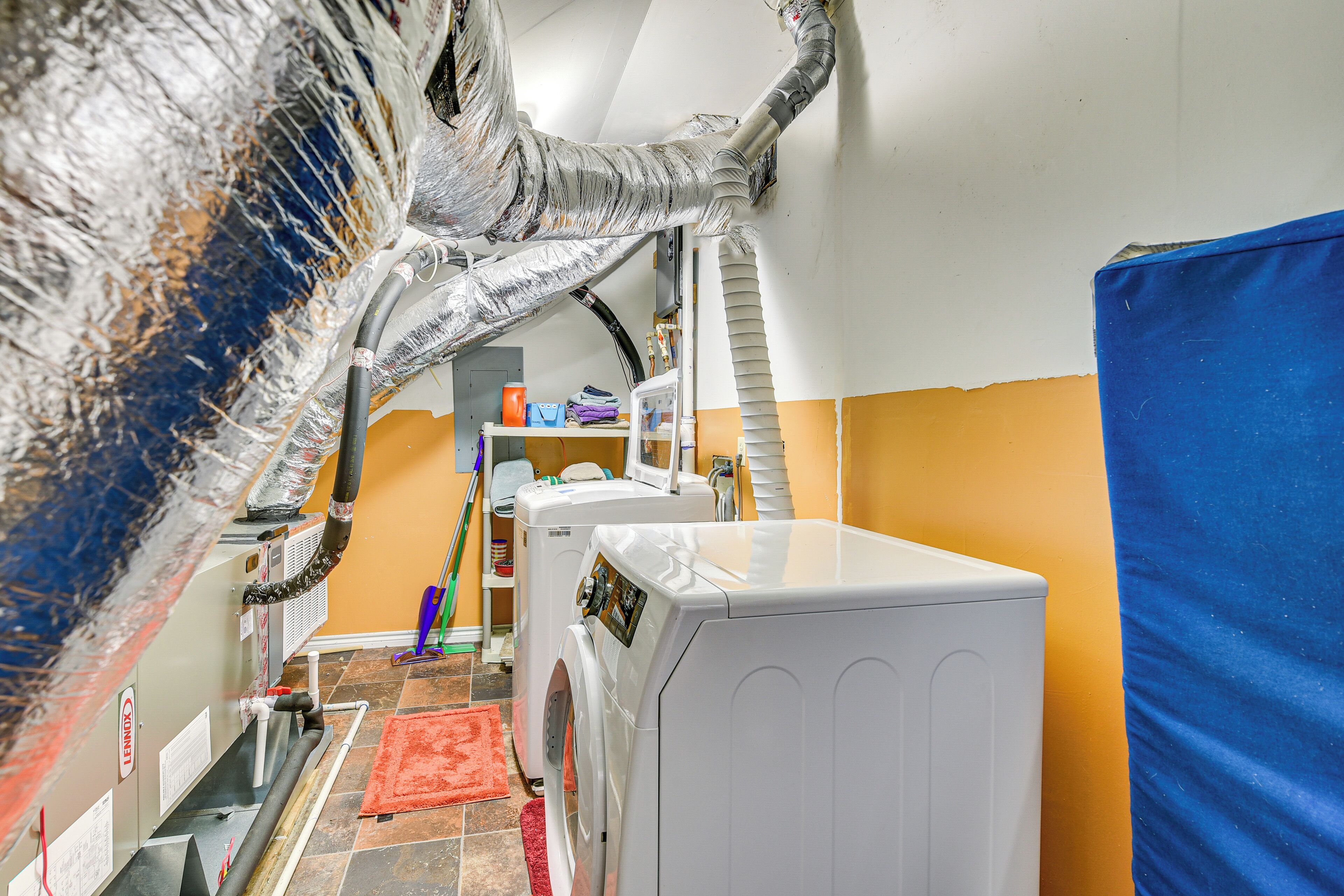 A laundry area with a washing machine, dryer, and a hose system.