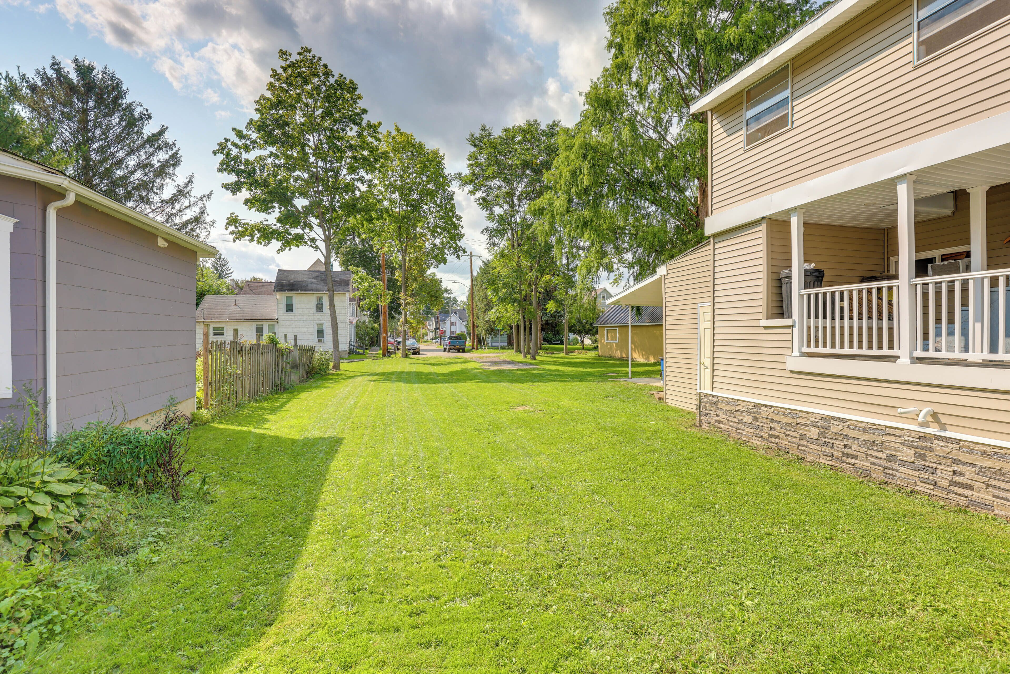A residential area with houses, a well-maintained lawn, and trees.