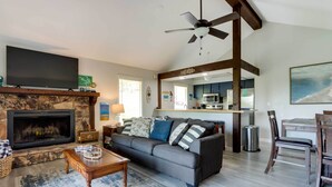 A living room with a fireplace, a sofa, a coffee table, and a television. - 1 Mi to Margaritaville Resort! Getaway w/ Hot Tub (Osage Beach)