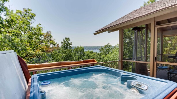 A hot tub with a wooden deck and a view of a lake. - 1 Mi to Margaritaville Resort! Getaway w/ Hot Tub (Osage Beach)